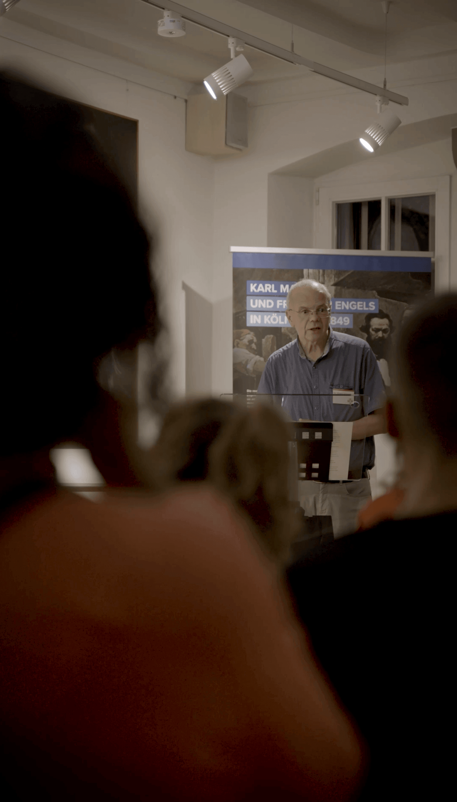 Ein Referent spricht bei einer Veranstaltung im Karl Marx Haus Trier vor Besucherinnen und Besuchern.